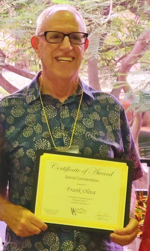 Frank Oliva standing in front of his art holding an award at the Pauahi Tower - Ultra Show III - Mar 13th - May 12th, 2023